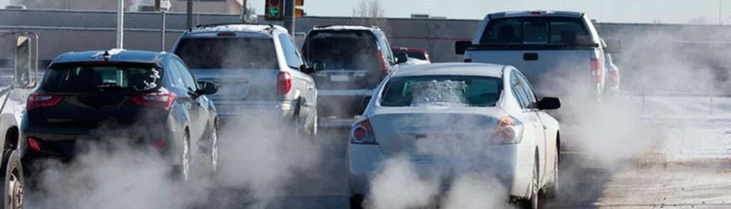 A picture of vehicles all lined up with emissions coming out of their ICE engine-powered vehicles' tailpipes